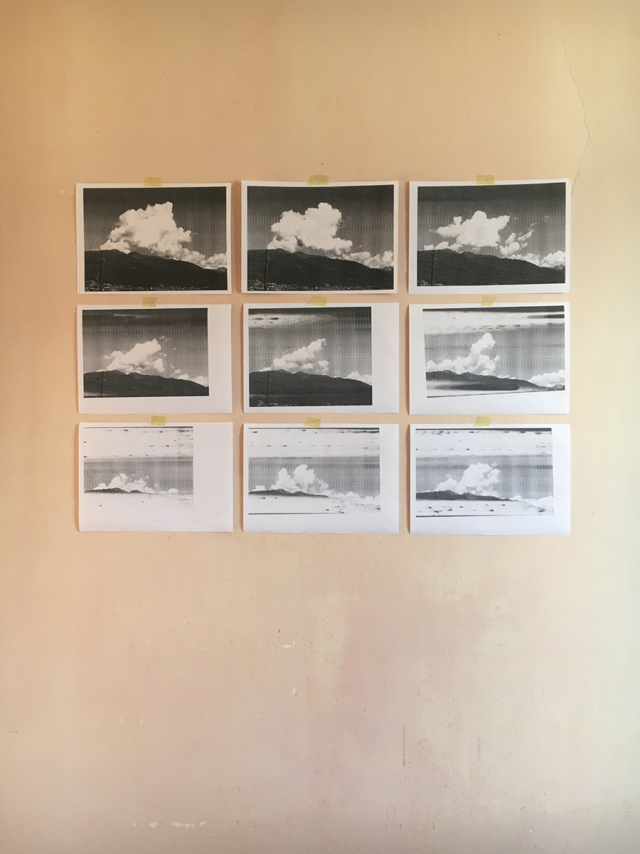 nine images of clouds over a mountain stuck to a wall